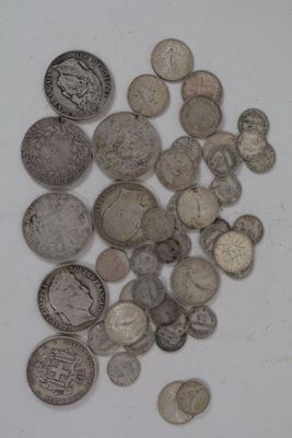a pile of old silver coins on a white surface