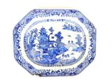 une assiette bleue et blanche sur laquelle est représenté un château