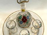 un plateau en verre sur lequel sont posés une carafe en verre et des verres