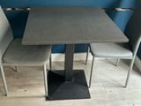 a table and two chairs in a room with a blue wall