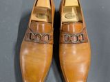 a pair of brown shoes on a gray surface