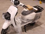 un scooter blanc avec un coffre à l'arrière