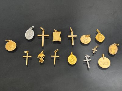 a collection of gold and silver crosses and coins on a black surface