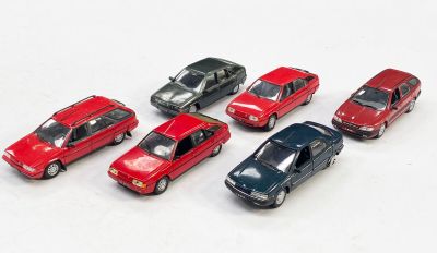 plusieurs petites voitures sont alignées sur une surface blanche