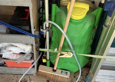 un conteneur vert avec un balai à côté d'un conteneur vert avec un couvercle jaune