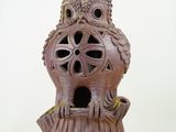 a birdhouse made out of a tree stump with a lamp on top