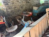 a room with a bike, a chair, and other items in it