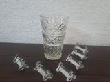 un verre d'eau et cinq morceaux de verre posés sur une table