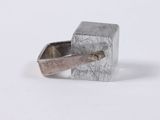 a silver ring with a metal handle on a white surface