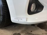 a close up of a white car with a sticker on it