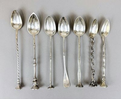 six silver spoons are lined up in a row on a table