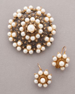 a close up of a brooch and earrings on a table