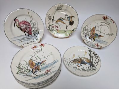 six assiettes sur lesquelles sont peints des oiseaux, posées sur une table