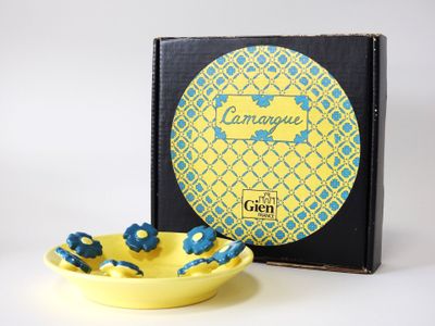 une image représentant un bol jaune contenant des perles bleues, à côté d'une boîte noire