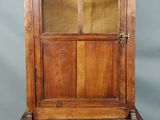 un vieux meuble en bois surmonté d'une porte en verre