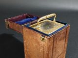 a small wooden box with a brass handle on a table