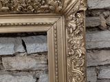 a picture of a picture of a gold frame in front of a stone wall