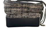 a black and white tweed purse with a chain strap