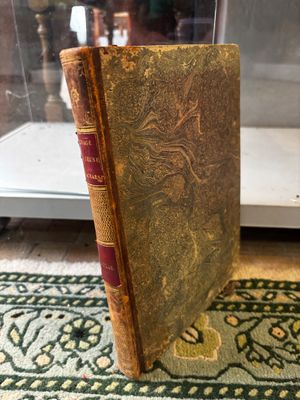 an old book sitting on top of a rug next to a glass case