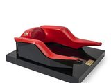 a red object on a black stand on a white background
