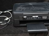 a black printer sitting on a black surface next to a charger