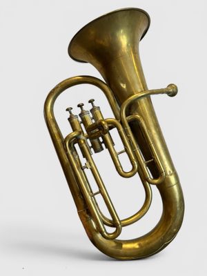 On voit un vieux tuba en laiton sur fond blanc.