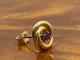a pair of earrings sitting on top of a wooden table