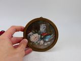 quelqu'un tient dans ses mains une image miniature représentant un vase avec des fleurs dedans