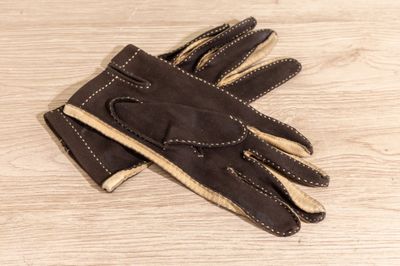 brown leather gloves on a wooden table with a white background