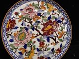 a plate with a floral design on it next to a plate with a flower design on it