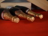 three bottles of wine are lined up on a red table