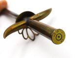 a small metal object with a wooden handle on a white surface