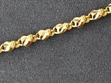 a close up of a gold chain on a black surface