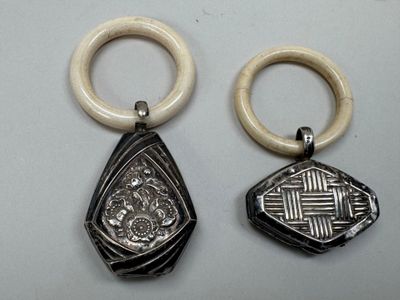 two pieces of silver and ivory jewelry on a white surface