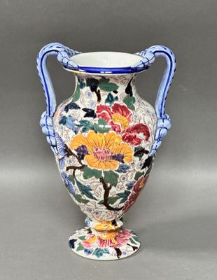 un vase avec un motif floral posé sur une table