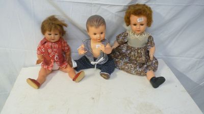 three dolls sitting next to each other on a table