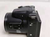 a black digital camera sitting on a white surface