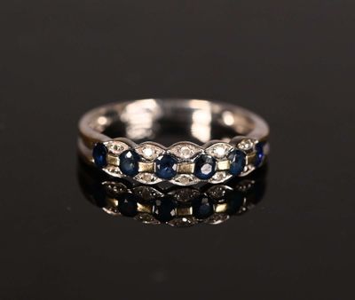 a close up of a diamond and sapphire ring on a black surface