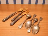 five spoons, two forks, and a spoon on a table