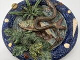 une assiette bleue décorée d'un poisson et de plantes