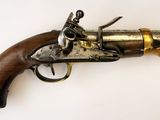 gros plan d'un pistolet avec un manche en bois sur une surface blanche