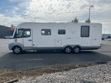 a small white rv parked in a parking lot