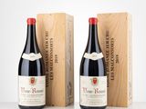 deux bouteilles de vin rouge dans des caisses en bois posées sur une table