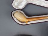 a wooden pipe in a case on a table