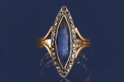 Gros plan sur une bague en or ornée d'une pierre bleue