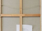 an old window frame with a piece of fabric and a piece of paper in it