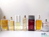several bottles of different types of perfume are lined up on a table