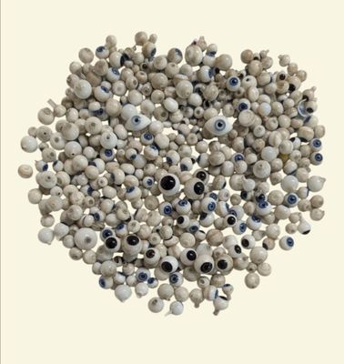 une image représentant un tas de perles blanches ornées d'yeux bleus