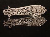 a close up of a pair of silver hair clips on a black surface