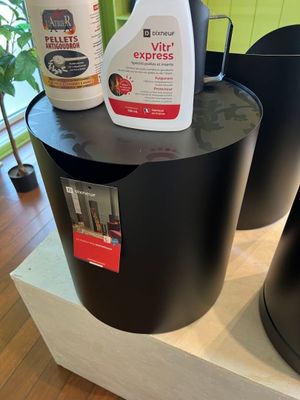two black trash cans sitting on top of a wooden table